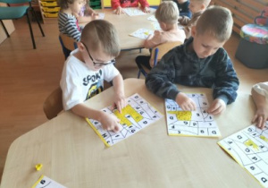 Mali chłopcy wyklejajają plasteliną.