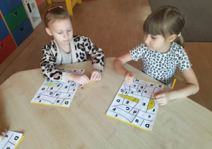 Dziewczynki siedzą przy stoliku.