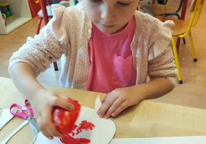 Dziewczynka trzyma jabłko.