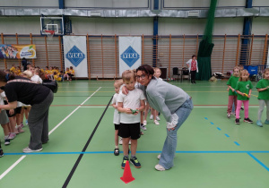 Nauczyciel obejmuje ramieniem chłopca.