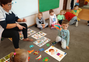 Chłopiec trzyma sylwetę papierowej czapki.