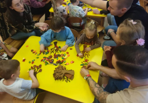 Dzieci wykonują jesienne drzewka.