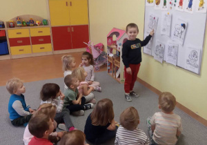 Dzieci siedzą,a chłopiec wskazuje prawa.