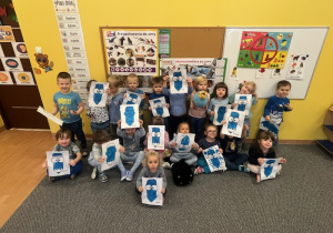 Wspólne zdjęcie dzieci z niebieskimi kredkami.