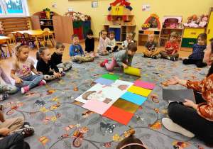 Dzieci siedzą i odkrywają kartki zgodnie z kodem.