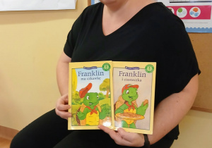 Pani pokazuje ilustrację podczas czytania.