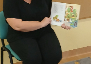 Pani pokazuje ilustracje książki.