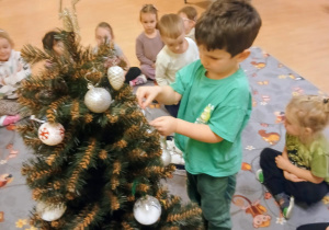 Chłopiec zawieszki bombki na choince.