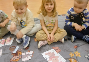 Dzieci układają obrazki z misiami.