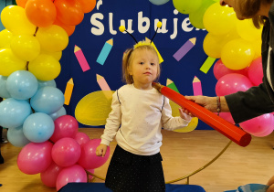 Pani dyrektor pasuję dziewczynkę na przedszkolaka.