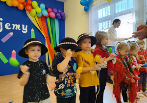 Dzieci w kapeluszach i chustkach.