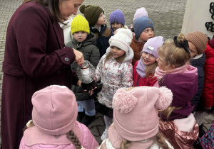 Kobieta zapala znicz.