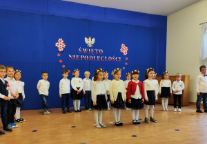 Dziewczynki na scenie recytują wiersz.