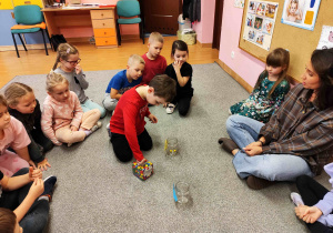 Chłopiec wyjmuje ze słoika kolorowe koraliki.