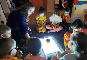 Przedszkolaki patrzą na podświetlany ekran.