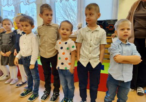 Dzieci stoją w rzędzie.