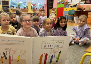 Dzieci oglądają ilustracje czytanej książki.