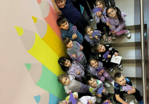 Przedszkolaki stoją na schodach.