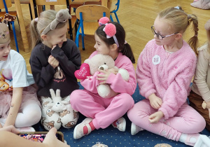 Dzieci bawią się misiem.