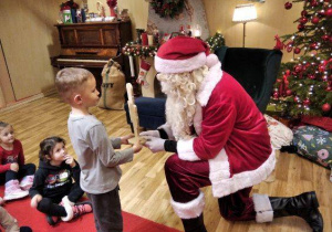 Chłopiec daję Mikołajowi prezent.