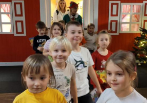 Małe dzieci wychodzą z domku Mikołaja.