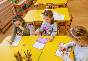 Dzieci rysują ulubione postacie z bajek na ekranie laptopa.