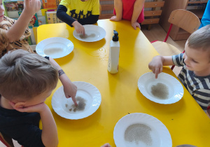 Dzieci wykonują eksperyment z pieprzem.