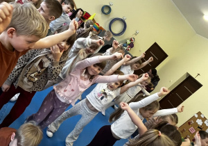 Dzieci maja uniesione ręce do góry.