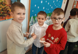 Chłopcy łamią się opłatkiem.