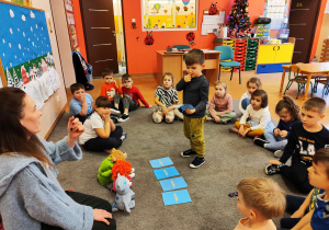 Dzieci w kręgu siedzą na dywanie.