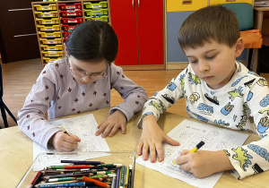 Dzieci kolorują rysunek.