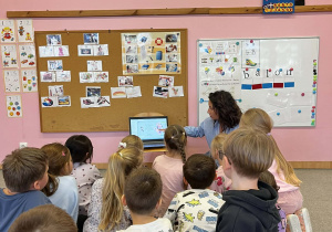 Małe dzieci siedzą na dywanie.