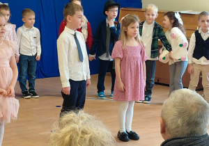 Dziewczynka i chłopiec występują na scenie.