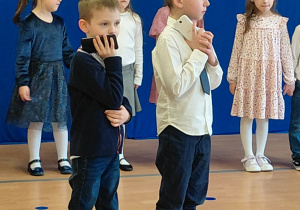 Dwaj chłopcy tzrymają telefony w dłoniach.