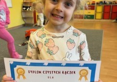 Dziewczynka trzyma dyplom.