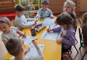 Dzieci siedzą i wykonują kartę pracy.