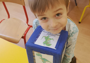 Chłopiec trzyma kostkę z obrazkami.