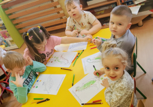 Dzieci kolorują dinozaury zgodnie z kodem.